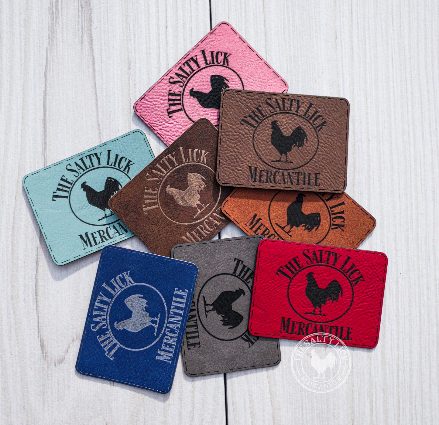Custom engraved leatherette patches with adhesive backing, featuring detailed design work for branding or decorative use.