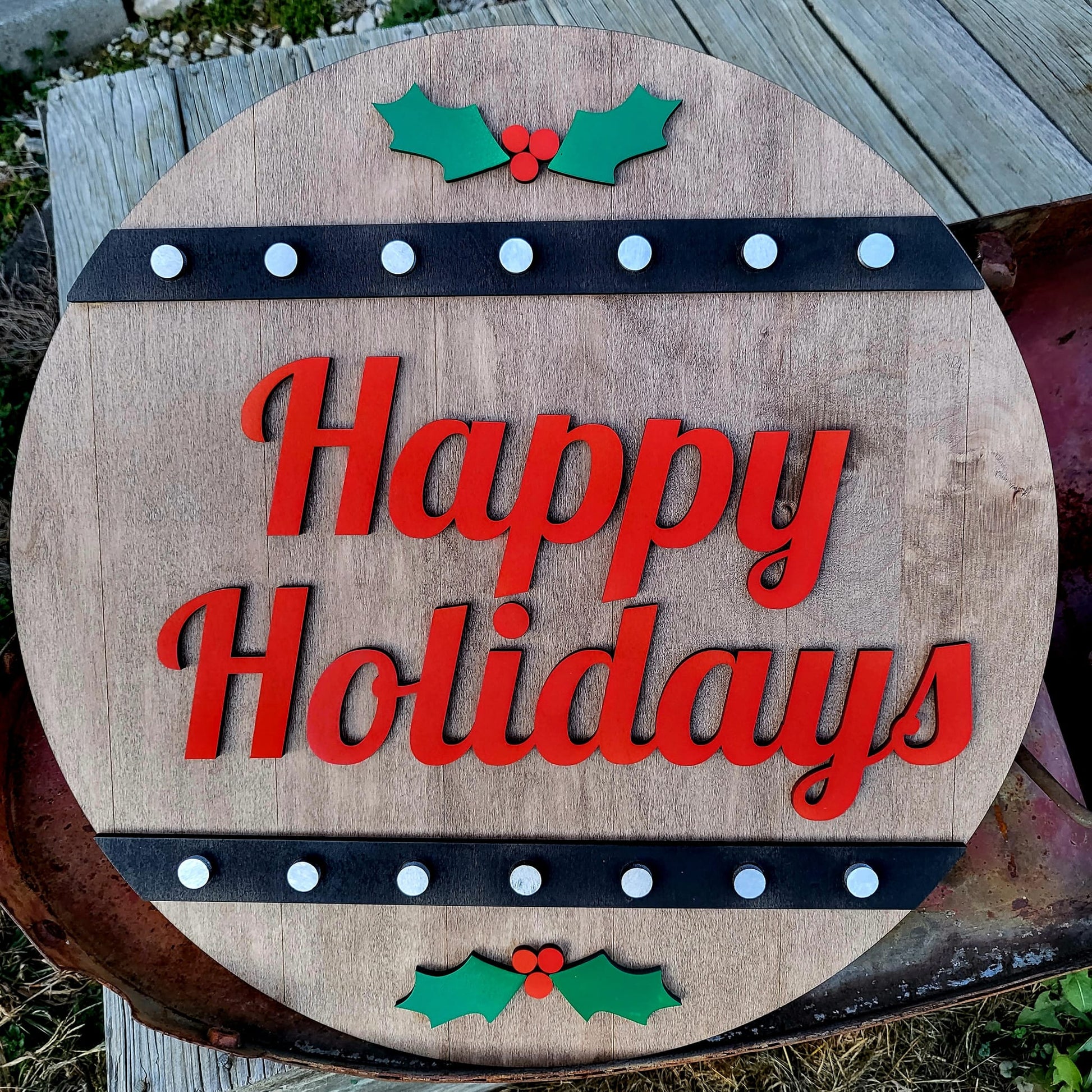 Round Christmas sign with "Happy Holidays" message from The Hollow & Hill Co., featuring festive holiday design and bold lettering.